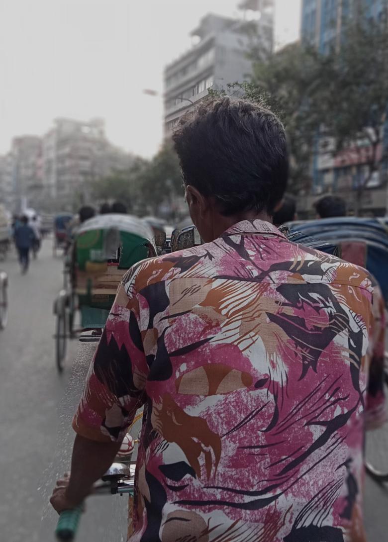 A rickshaw puller on a busy Dhaka street.